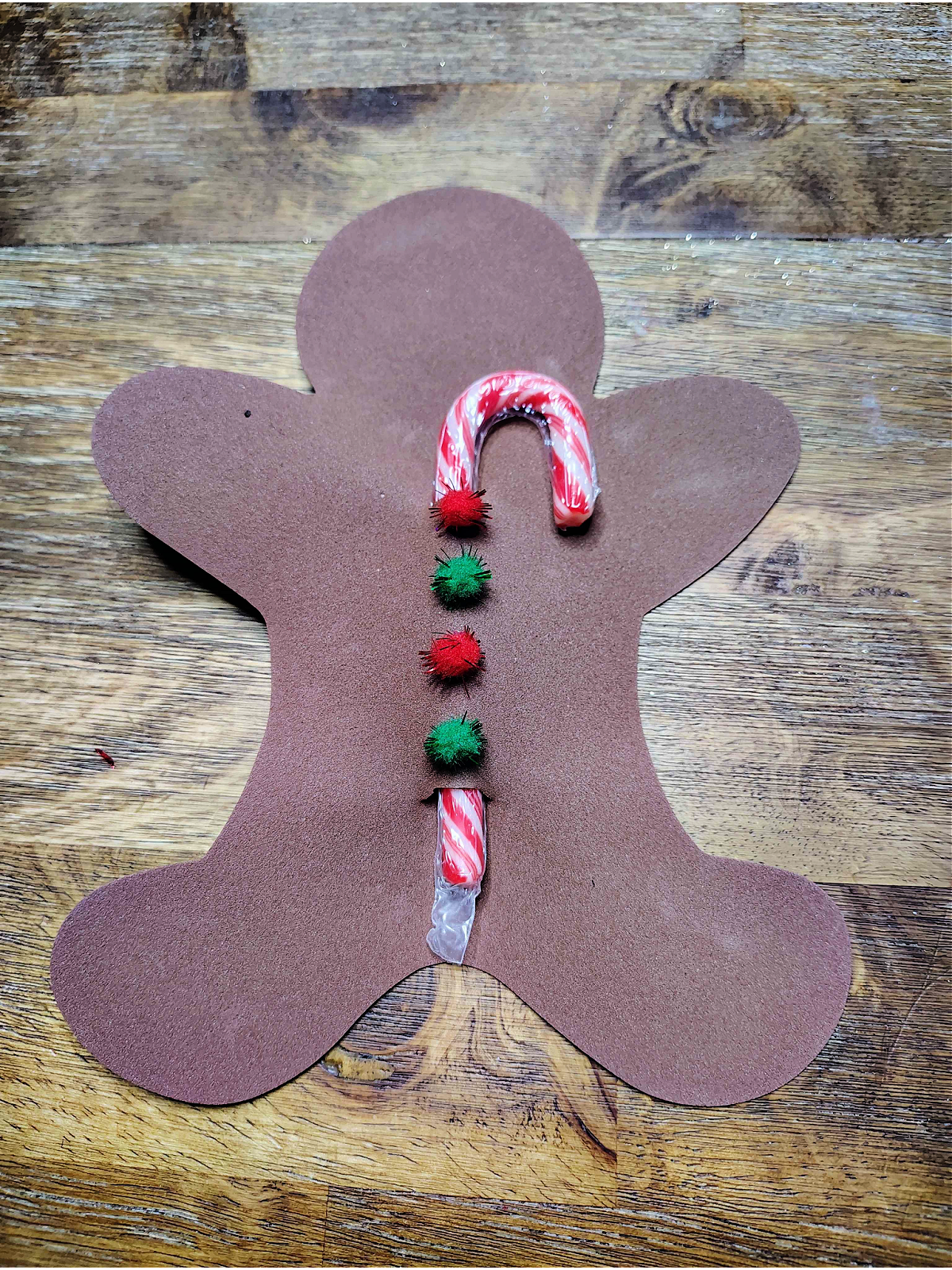 Candy Cane Holder Craft- Step 3 -Red and green pom poms added as buttons - Kids Activities Blog