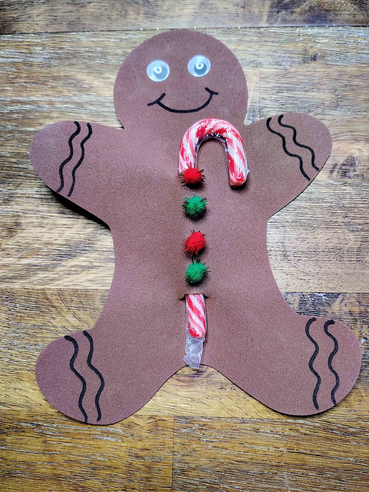 Candy Cane Holder Craft- Step 5- Black squiggles and a smile added - Kids Activities Blog