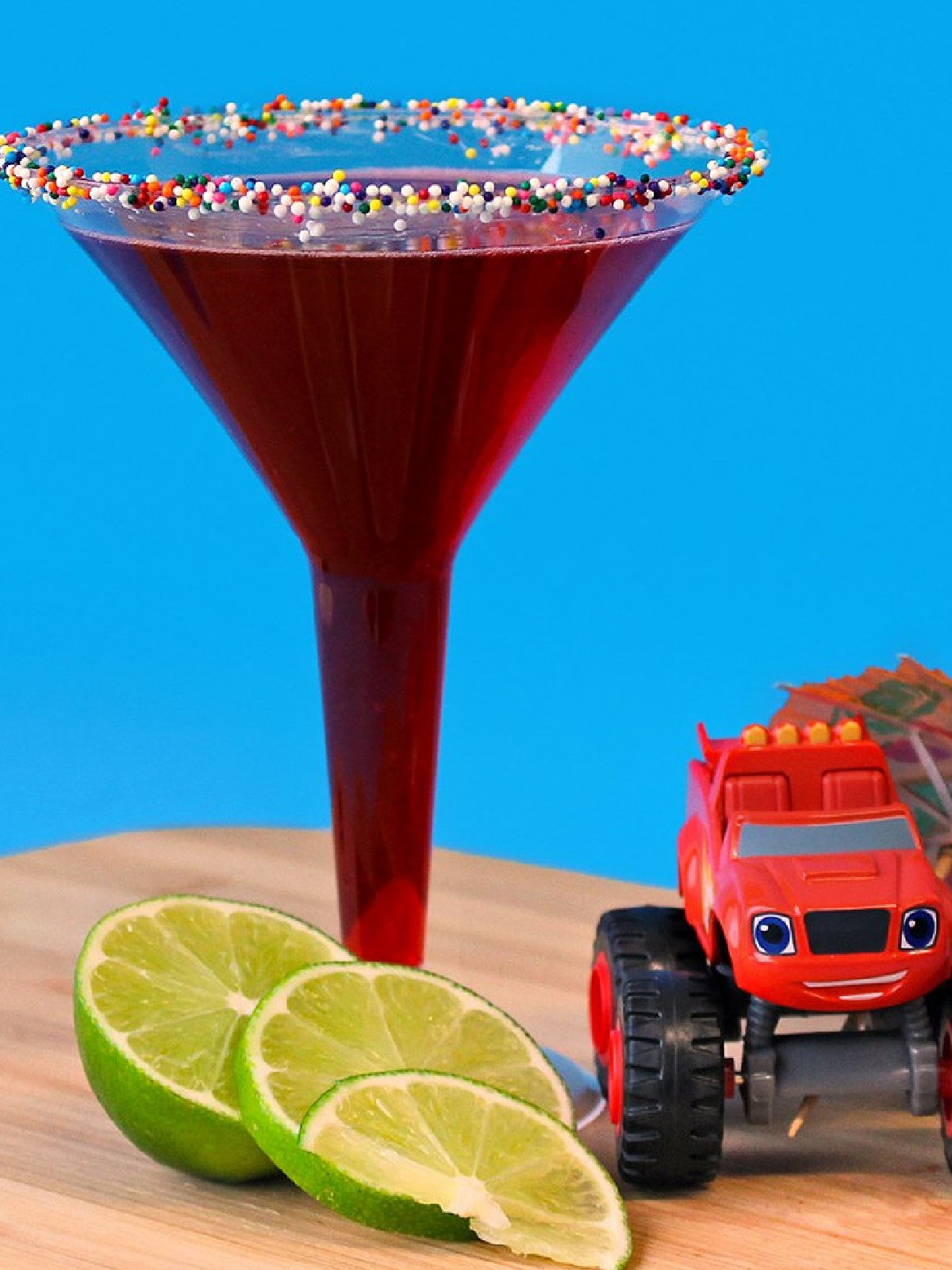 New Years Eve Mocktails- blaze toy next to limes next to red drink with sprinkles-Kids Activities Blog