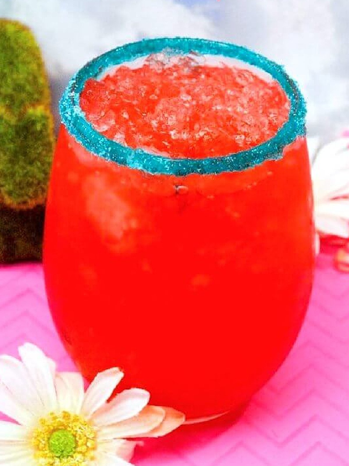 New Years Eve Mocktails- red drink with blue rim and a white flower -Kids Activities Blog