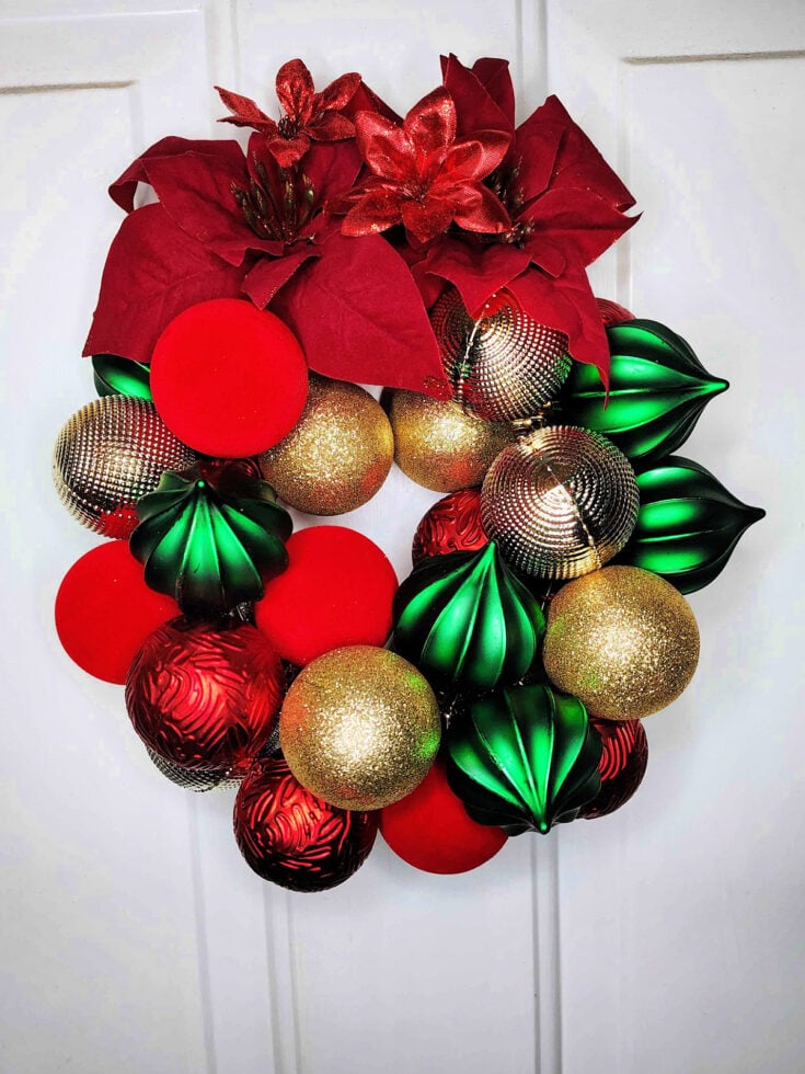 Christmas Ornament Wreath- Finished-Gold, green, silver, red ornaments and flowers hanging on a door in wreath form - Kids Activities Blog