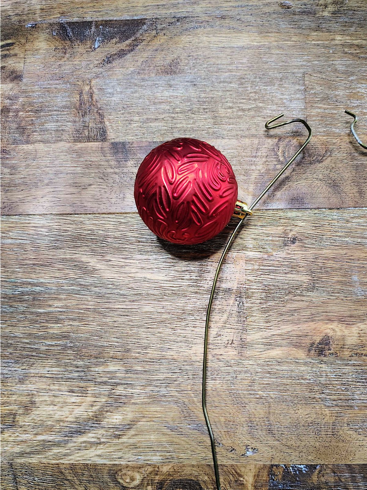 Christmas Ornament Wreath- Step 2- Ornaments thread on hanger- Kids Activities Blog