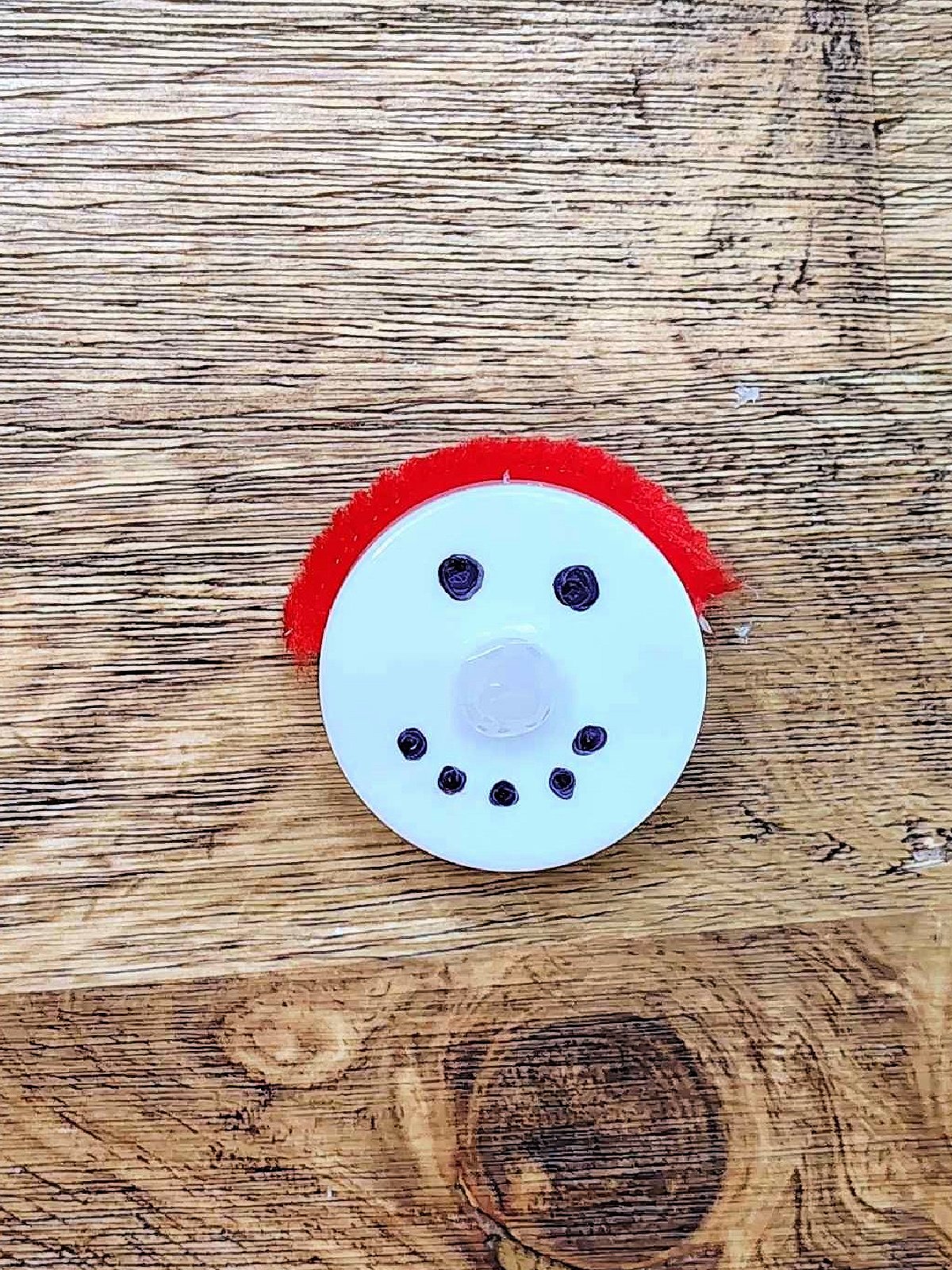 Snowman Craft- Step 3- hot glue the pipe cleaner, red, on top of the candle- Kids Activities Blog