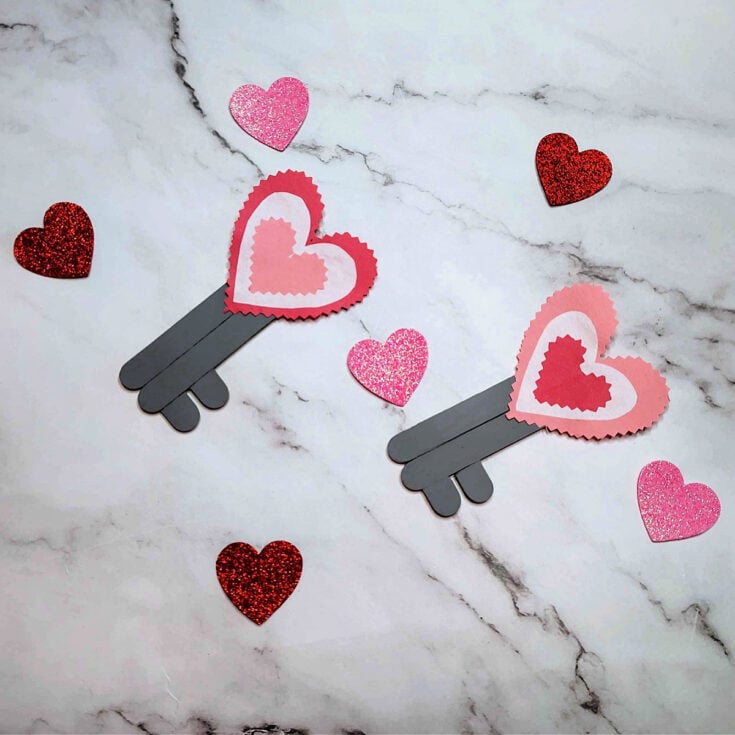 Key To My Heart Craft- Completed Key To The Heart Craft with keys, marble background, and glitter hearts- - Kids Activities Blog