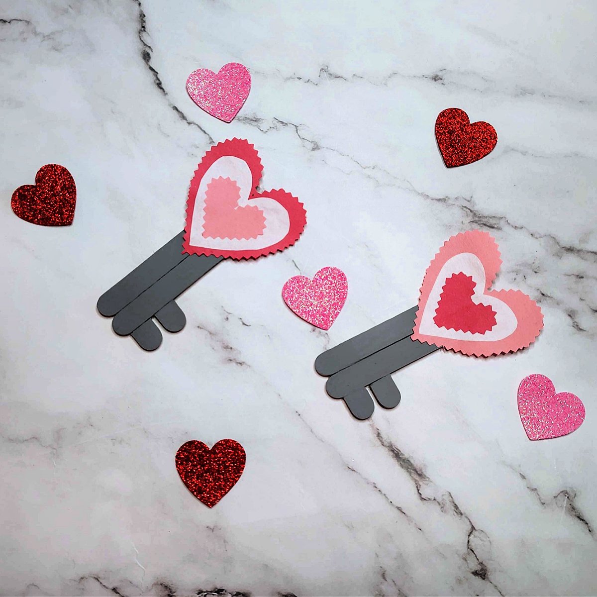 Key To My Heart Craft- Completed Key To The Heart Craft with keys, marble background, and glitter hearts- - Kids Activities Blog