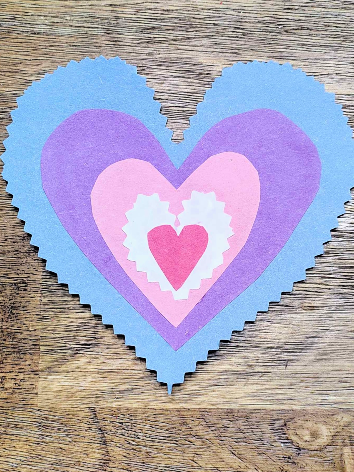 Butterfly Craft- Step 4- Blue heart with a purple and pink heart in it with a white heart and red heart- Kids Activities Blog