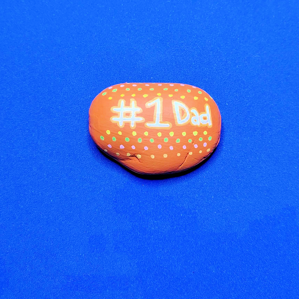 Father's Day Painted Rock Craft- Step 3- orange rock with #1 dad and polka dots-Kids Activities Blog