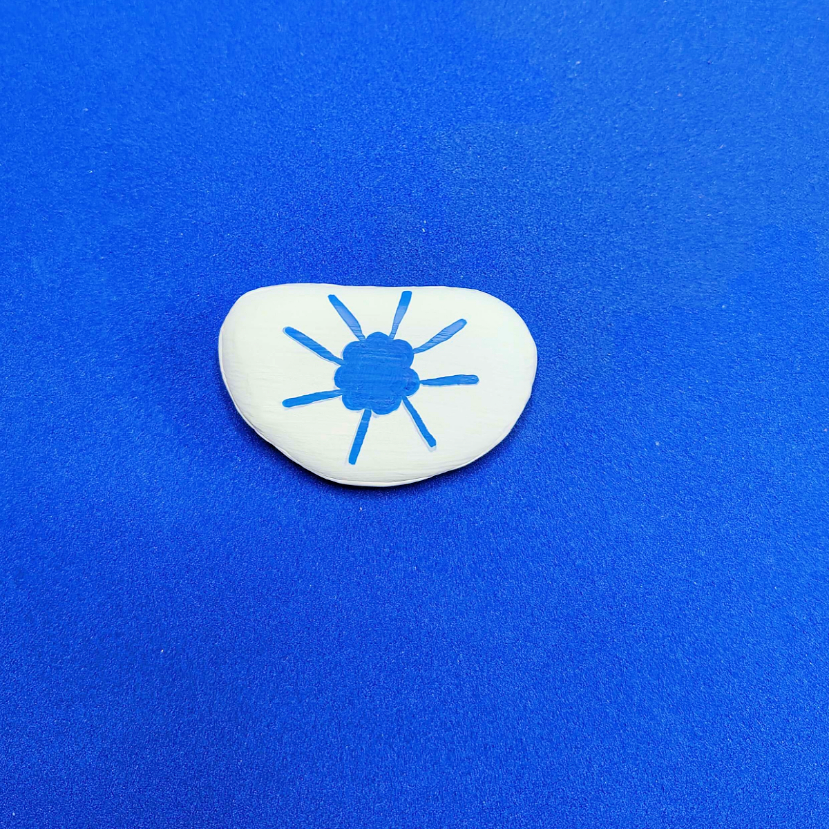 Patriotic Rock Painting Craft- Step 3- 8 blue lines drawn from flower-Kids Activities Blog