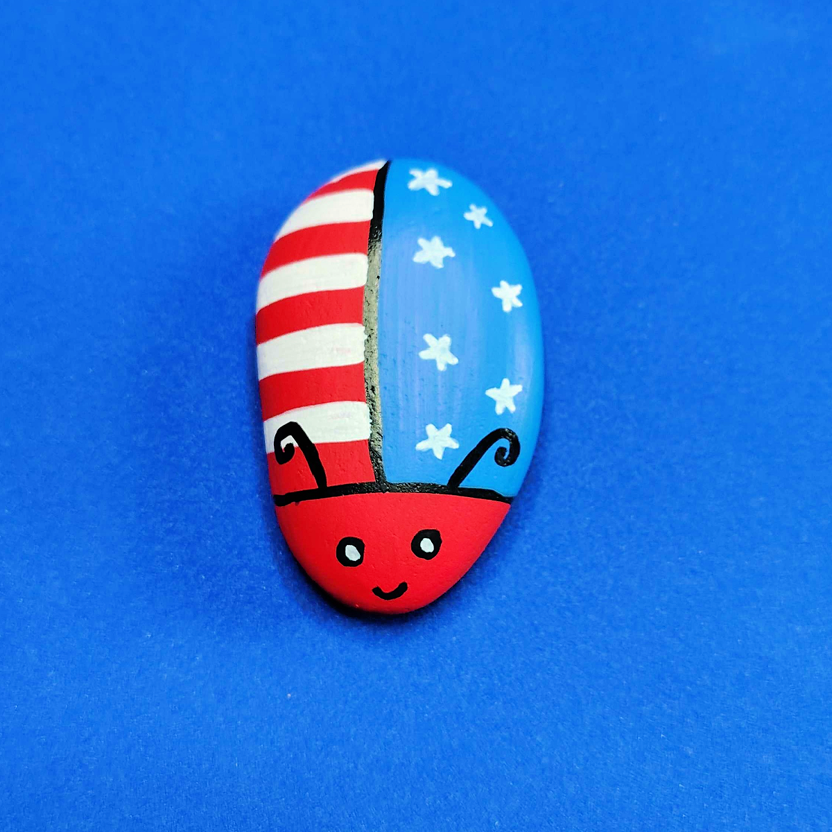Patriotic Rock Painting Craft- Bug with red and white stripes and blue and white stars-Kids Activities Blog
