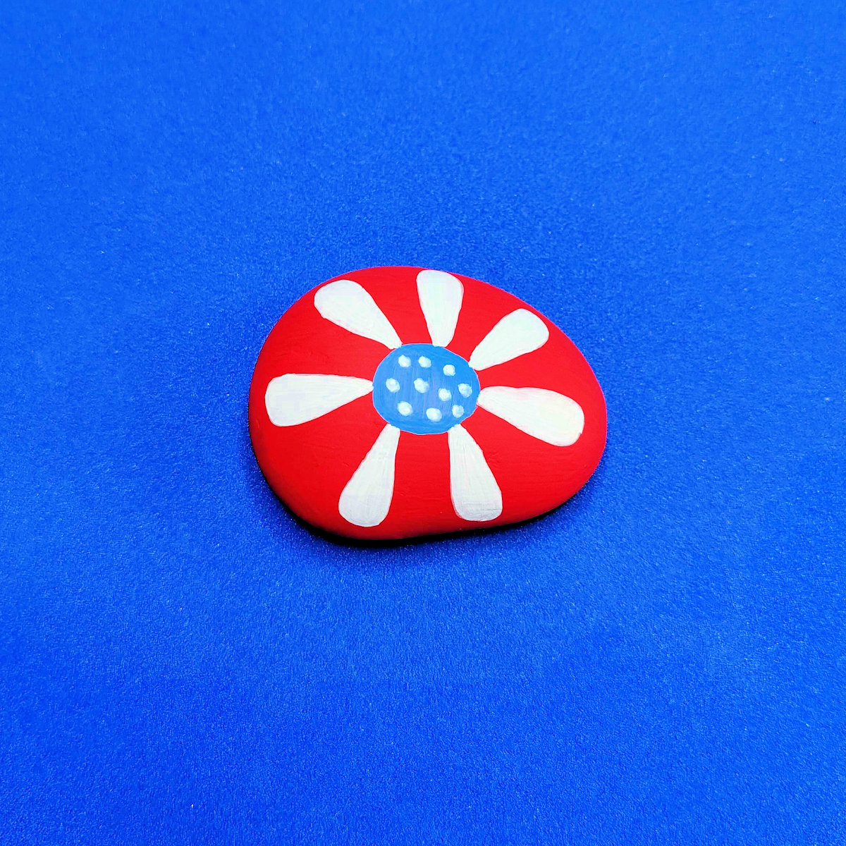 Patriotic Rock Painting Craft- Red rock with white and blue flower -Kids Activities Blog