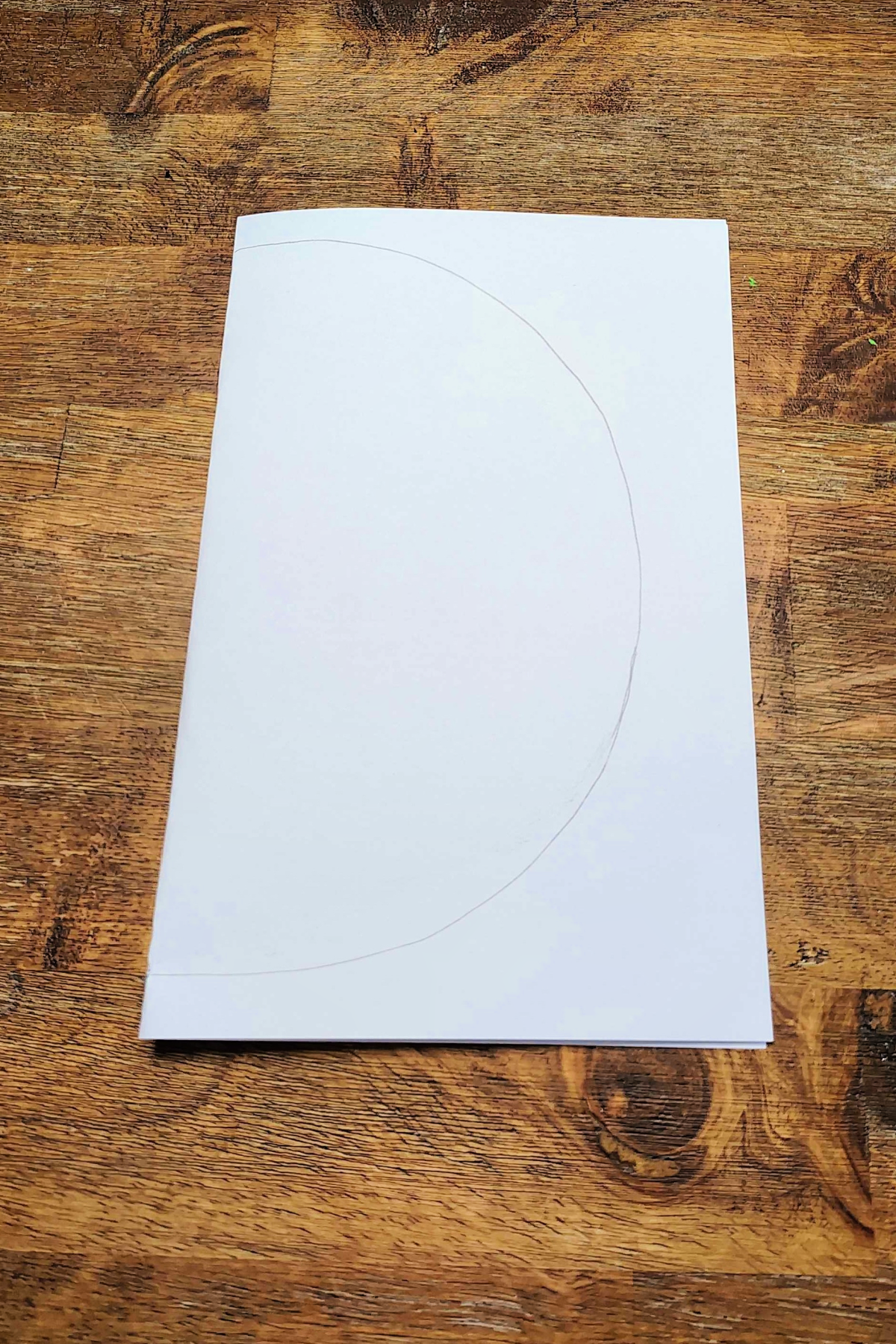 Watermelon Craft- Step 1 - Piece of paper folded in half with half circle-Kids Activities Blog