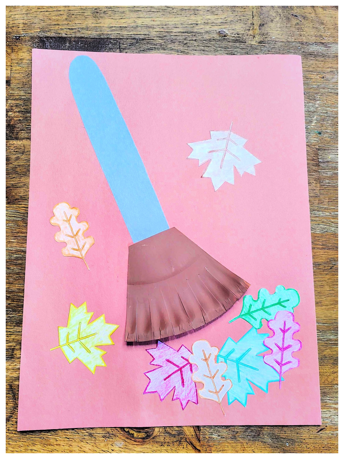 Leaf Craft- Step 6- leaves glued around the rake on brown construction paper - Kids Activities Blog