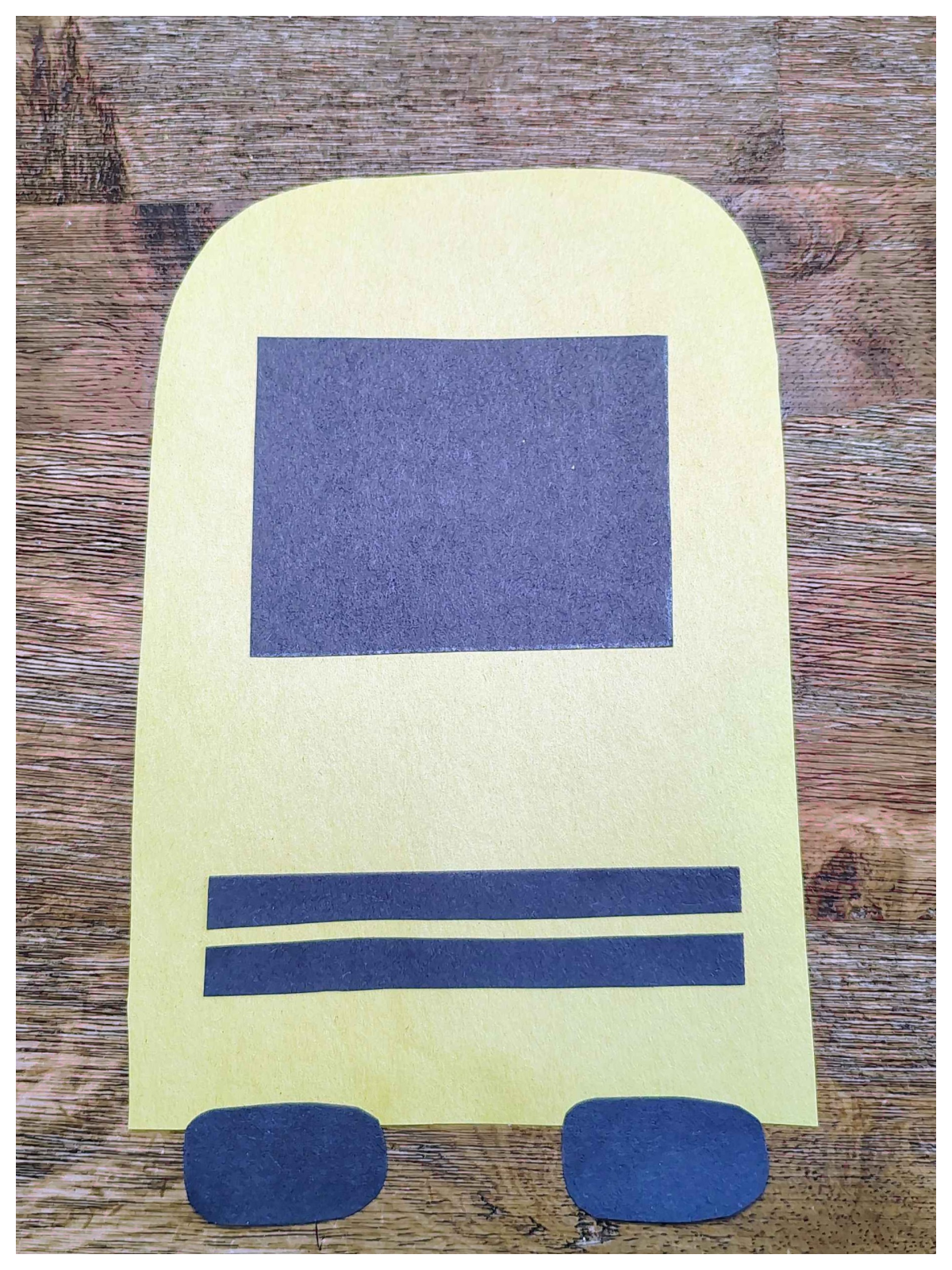Paper School bus craft- Step 4- Glue the tired, windshield, and grill on the bus- Kids Activities Blog