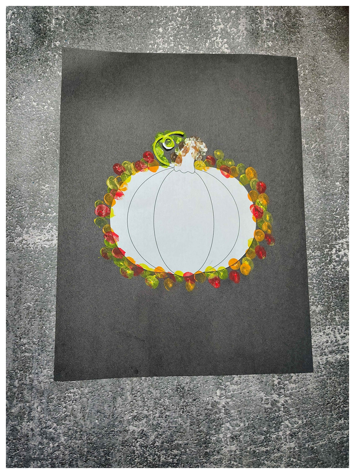 Pumpkin Craft- Step 2 - finger paint orange, yellow, green, brown, white, around the pumpkin on the black paper - Kids Activities Blog