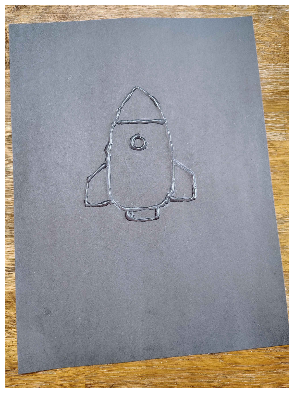 Rocket Craft- Step 2- Outline rocketship with hot glue -Kids Activities Blog