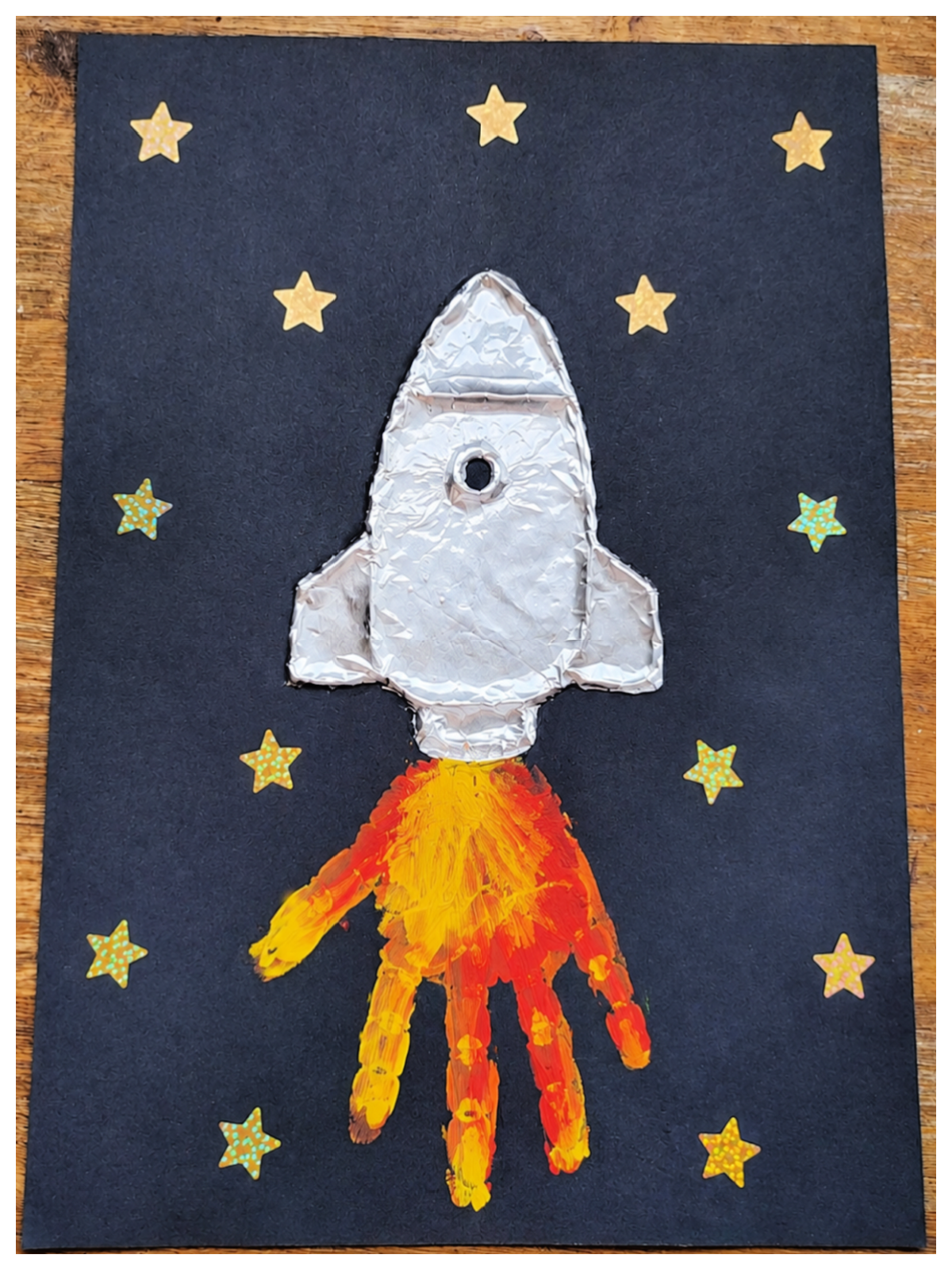 Rocket Craft- Step 5 - Add gold stars to the black paper -Kids Activities Blog